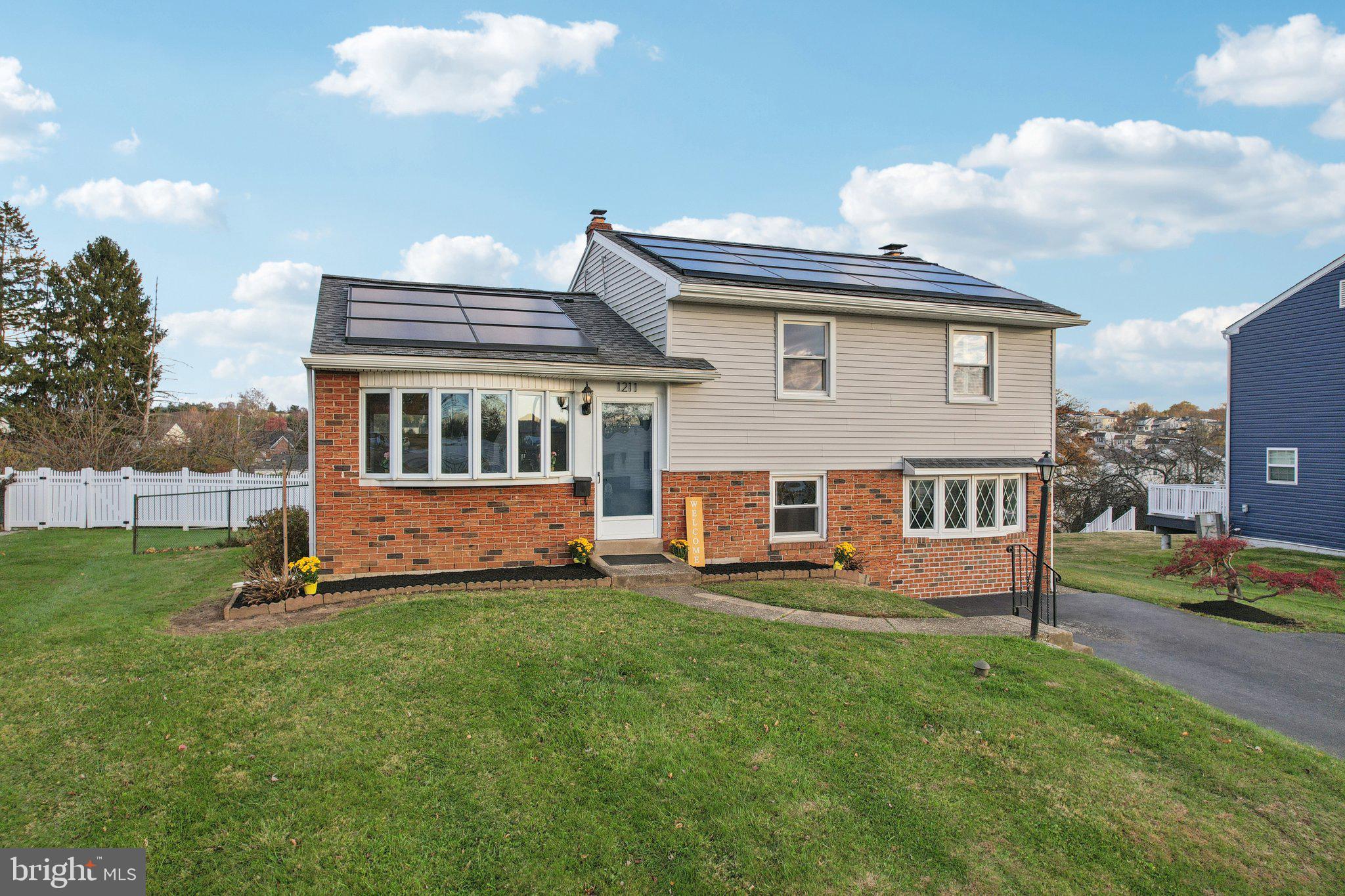 1211 Woodside Road Conshohocken, PA 19428 - Photo 5 of 55 a front view of a house with a yard table and chairs