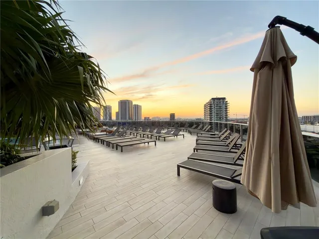 a view of a terrace with lawn chairs