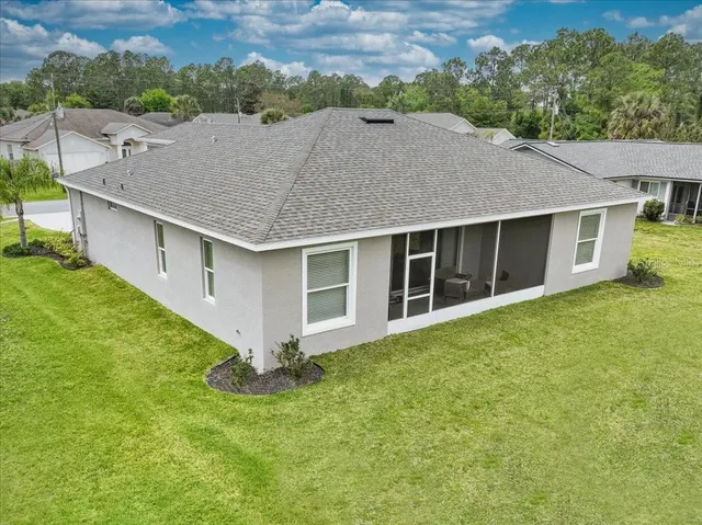 a aerial view of a house with a yard and a large tree