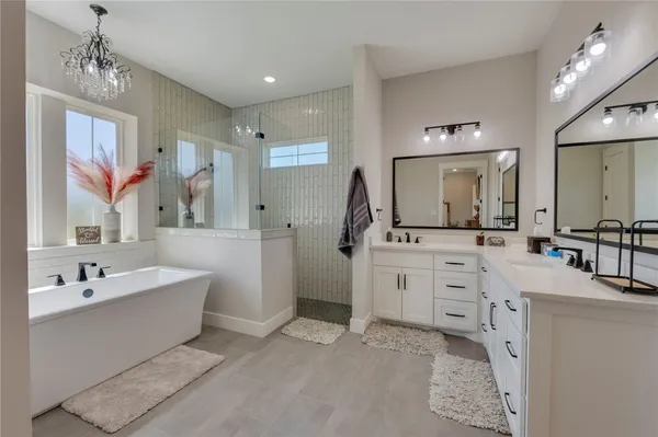 a spacious bathroom with a double vanity sink mirror and bathtub