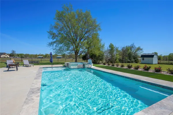 a view of house with swimming pool and yard