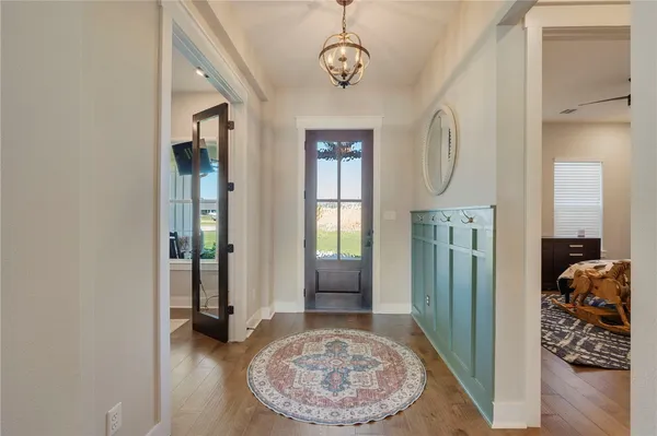 a view of a hallway with wooden floor and a living room