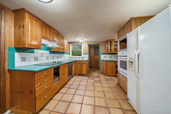a kitchen with stainless steel appliances granite countertop a stove top oven a sink and dishwasher