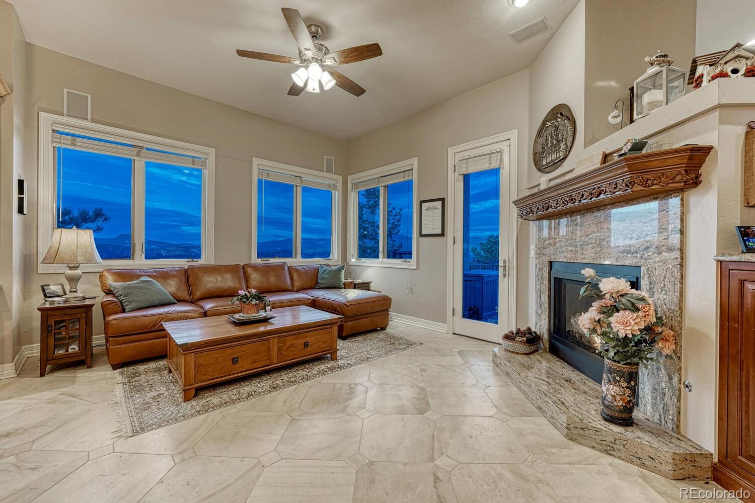 26344 Independence Trail Evergreen, CO 80439 - Photo 11 of 50 a living room with furniture a fireplace and a chandelier
