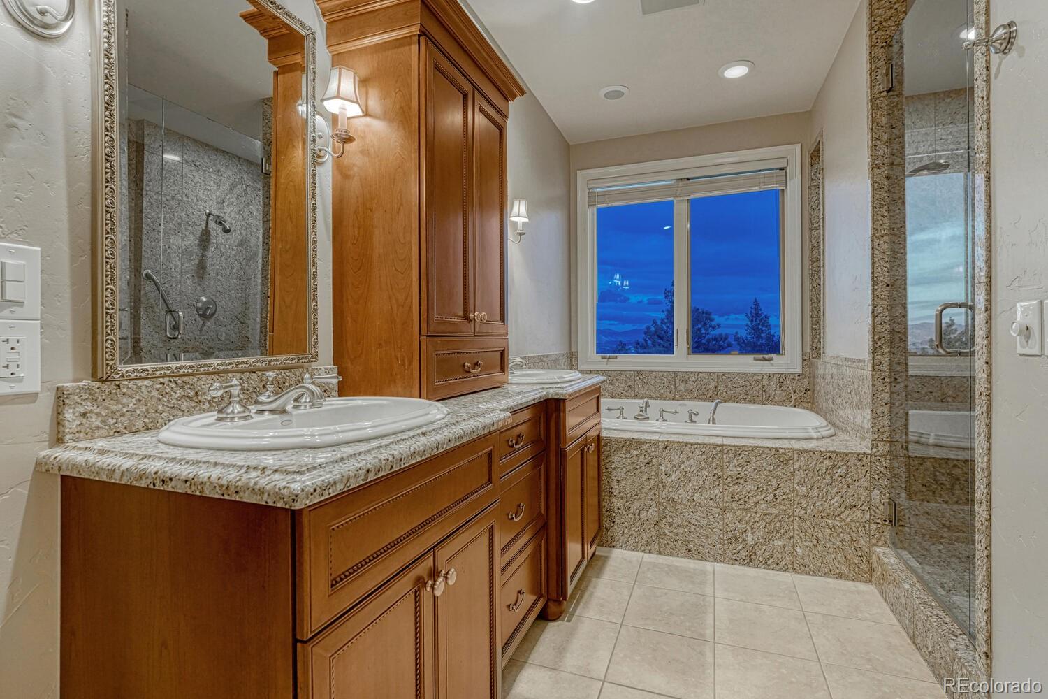 26344 Independence Trail Evergreen, CO 80439 - Photo 13 of 50 a bathroom with a granite countertop sink and a mirror
