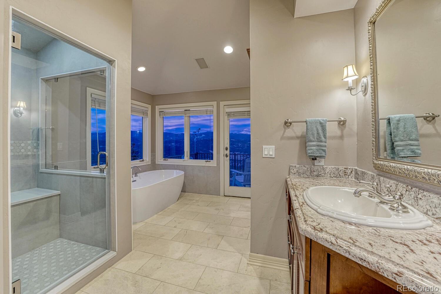 26344 Independence Trail Evergreen, CO 80439 - Photo 18 of 50 a bathroom with a granite countertop sink mirror and bathtub