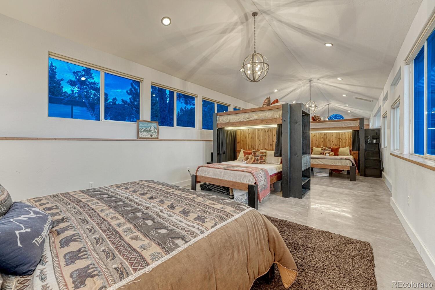 26344 Independence Trail Evergreen, CO 80439 - Photo 37 of 50 a bedroom with a large bed and a chandelier