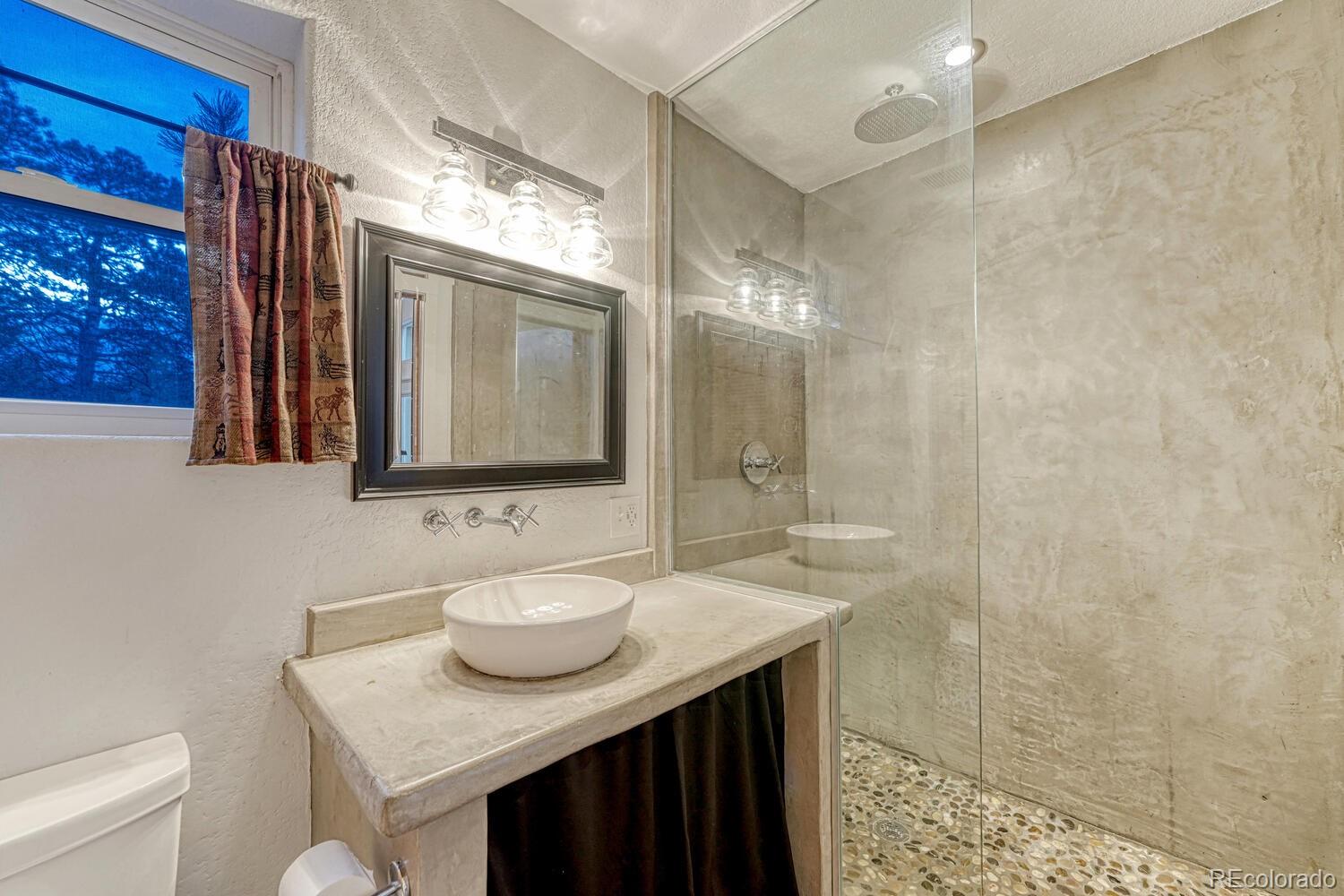 26344 Independence Trail Evergreen, CO 80439 - Photo 38 of 50 a bathroom with a sink a toilet and mirror