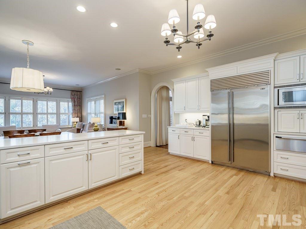 2304 White Oak Road Raleigh, NC 27608 - Photo 12 of 30 a large white kitchen with a refrigerator a stove a sink dishwasher a dining table and chairs