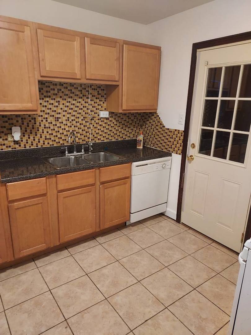 104 East 150th Street Harvey, IL 60426 - Photo 2 of 25 a kitchen with a sink and cabinets