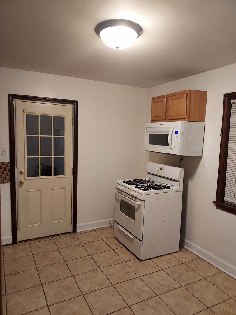 104 East 150th Street Harvey, IL 60426 - Photo 3 of 25 a white stove top oven sitting inside of a kitchen