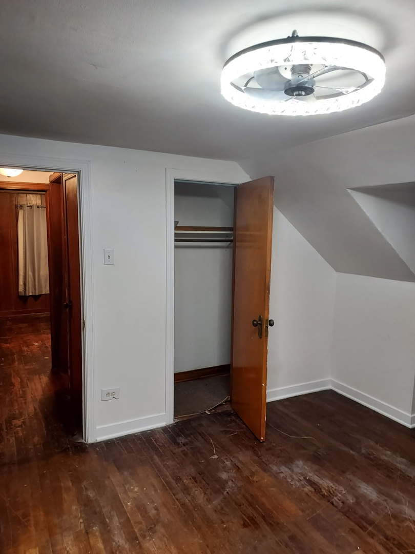104 East 150th Street Harvey, IL 60426 - Photo 9 of 25 a view of an empty room with wooden floor and a kitchen