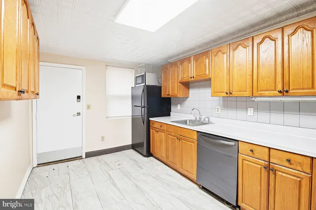 a kitchen with stainless steel appliances granite countertop a sink and a refrigerator