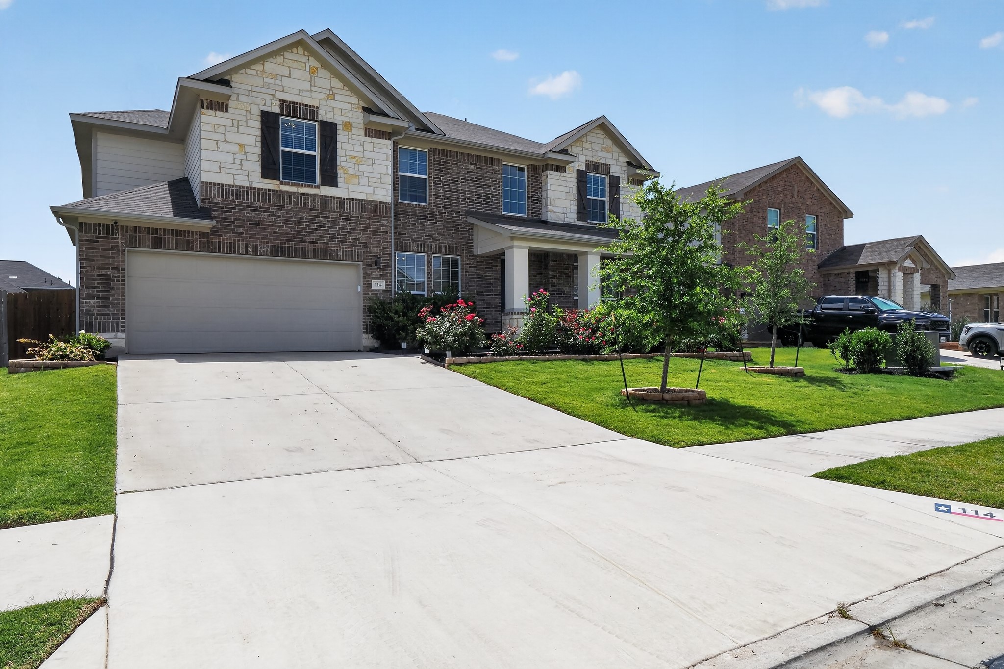 114 Bosco Road Hutto, TX 78634 - Photo 1 of 39 A classic brick and stone facade welcomes with lush landscaping and a wide driveway.