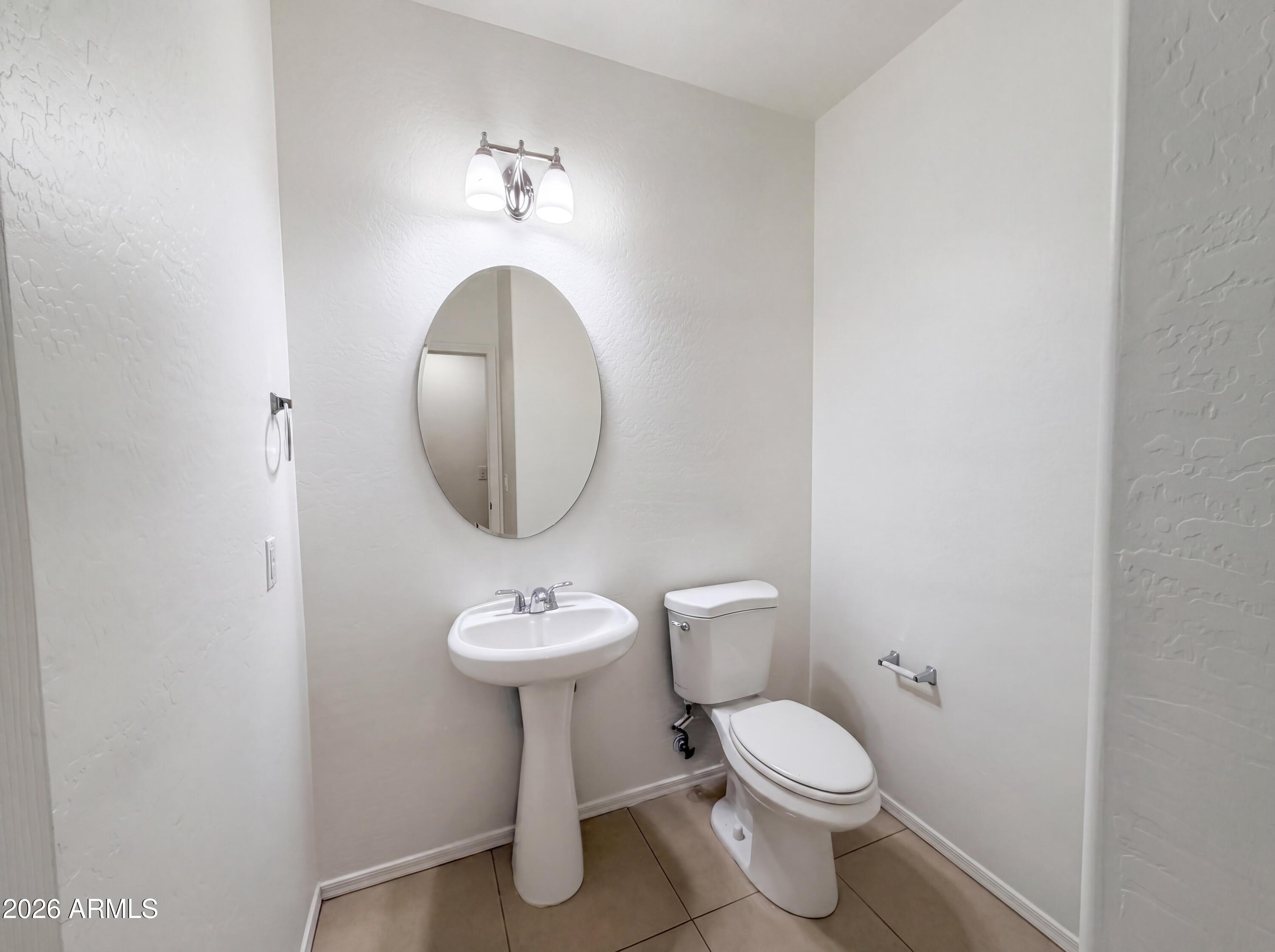 1718 West Colter Street, Unit 174 Phoenix, AZ 85015 - Photo 15 of 21 a bathroom with a toilet sink and mirror