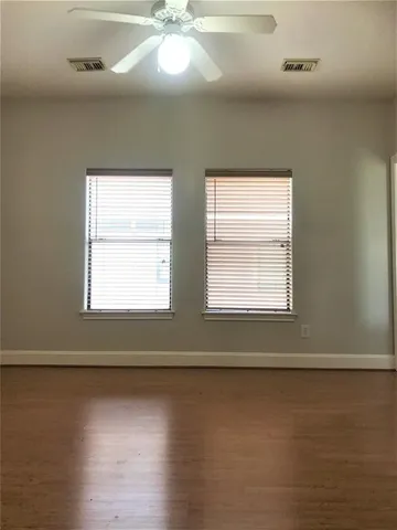 a view of empty room with window and wooden floor