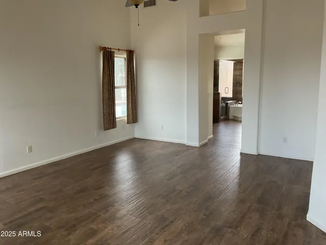 an empty room with wooden floor and a window