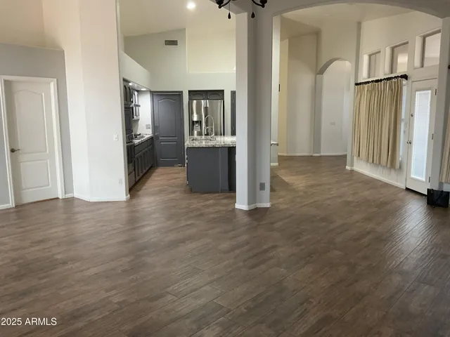 a view of a kitchen with wooden floor and a refrigerator