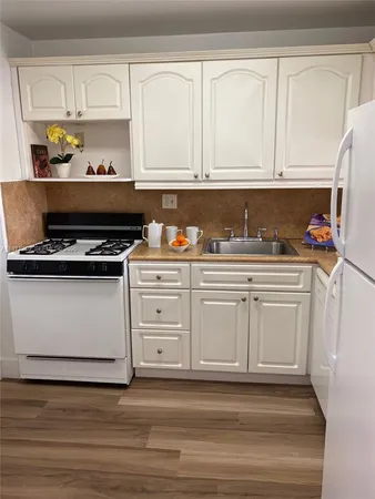 a kitchen with white cabinets and appliances