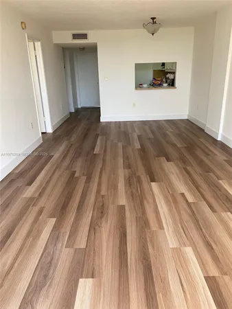 a view of a room with wooden floor