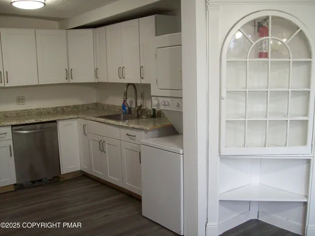 a kitchen with granite countertop white cabinets and white appliances
