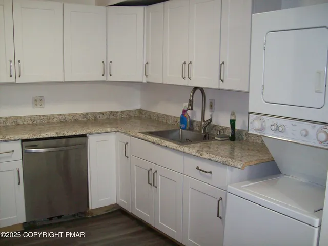 a kitchen with stainless steel appliances granite countertop white cabinets sink and granite counter tops