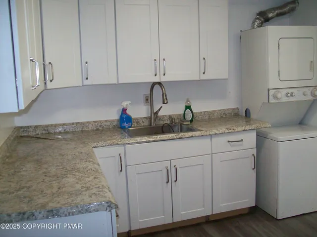 a kitchen with granite countertop white cabinets and sink