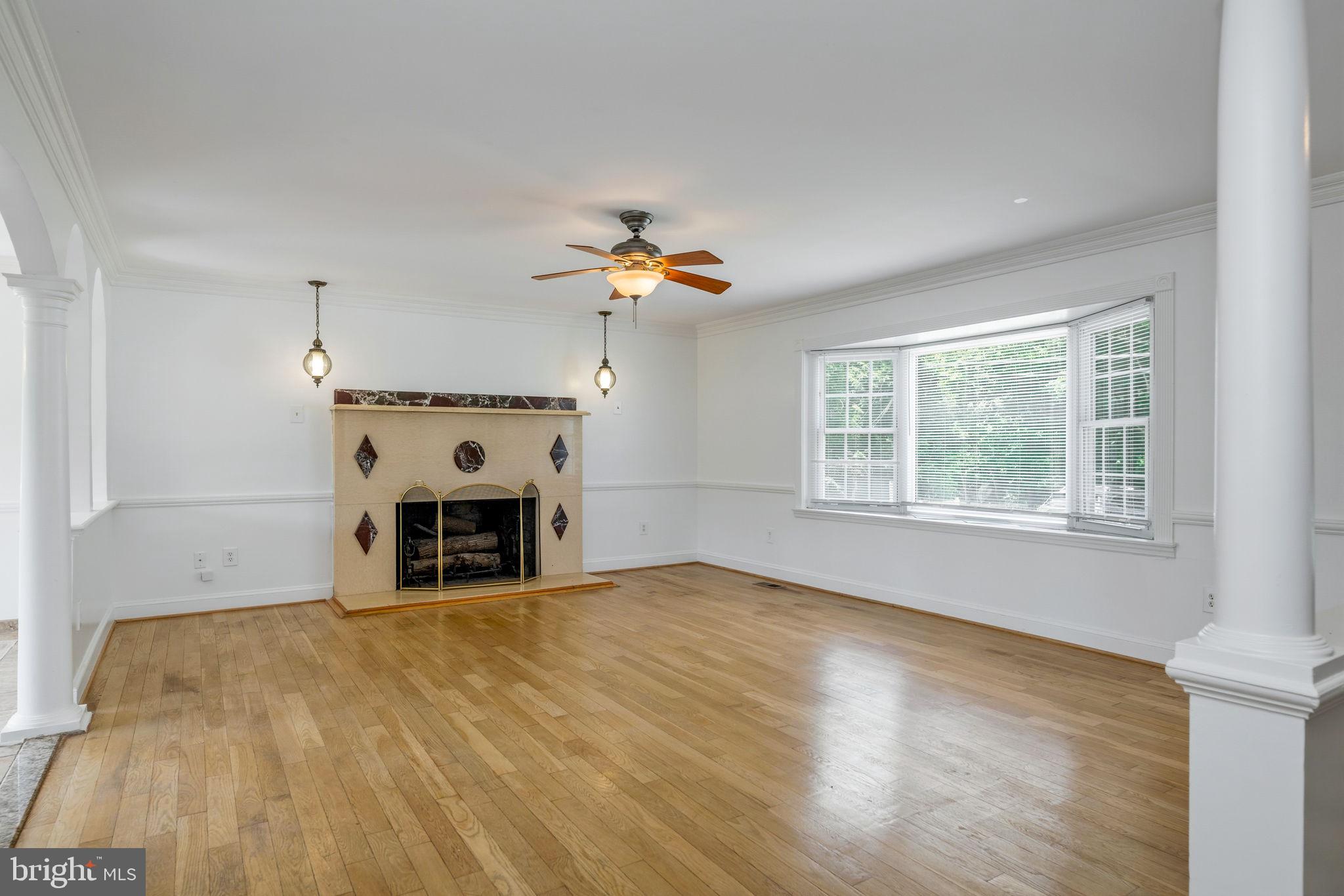 11325 Bacon Race Road Woodbridge, VA 22192 - Photo 6 of 54 a view of a livingroom with a fireplace a chandelier and windows