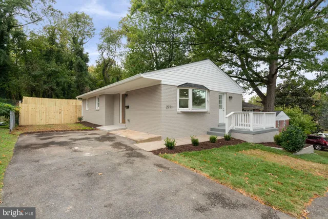 a front view of a house with a yard and trees
