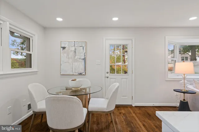 a dining room with wooden floor and windows