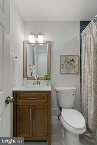 a bathroom with a granite countertop toilet a sink and a mirror