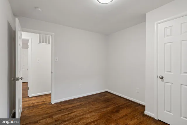 an empty room with wooden floor and closet