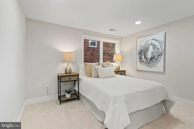 a bedroom with a bed and a painting on the wall