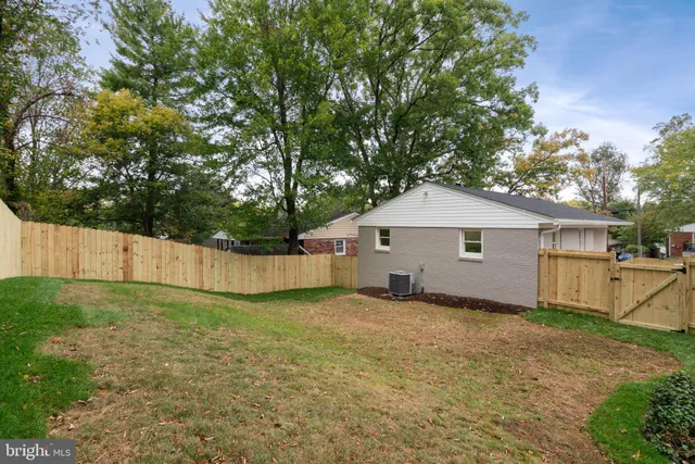 a view of a house with a yard and large tree