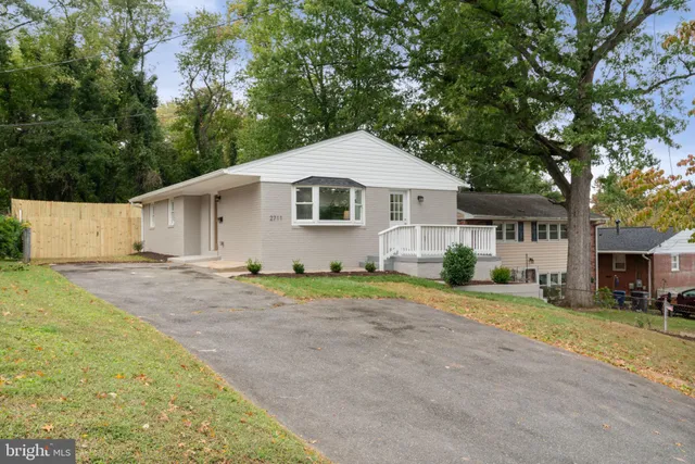 a front view of a house with a yard and trees