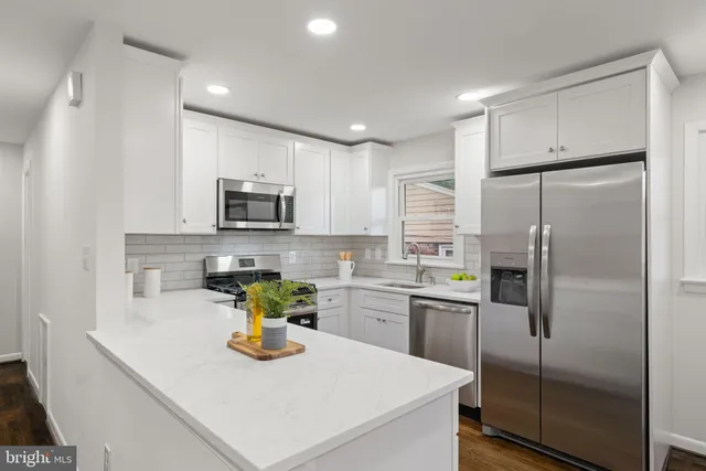 a kitchen with stainless steel appliances granite countertop a refrigerator a stove top oven a sink and dishwasher