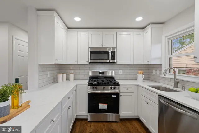 a kitchen with white cabinets and appliances