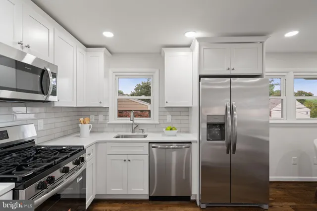 a kitchen with stainless steel appliances a refrigerator sink and microwave