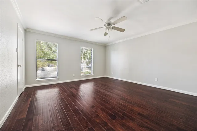 a view of an empty room with wooden floor and window