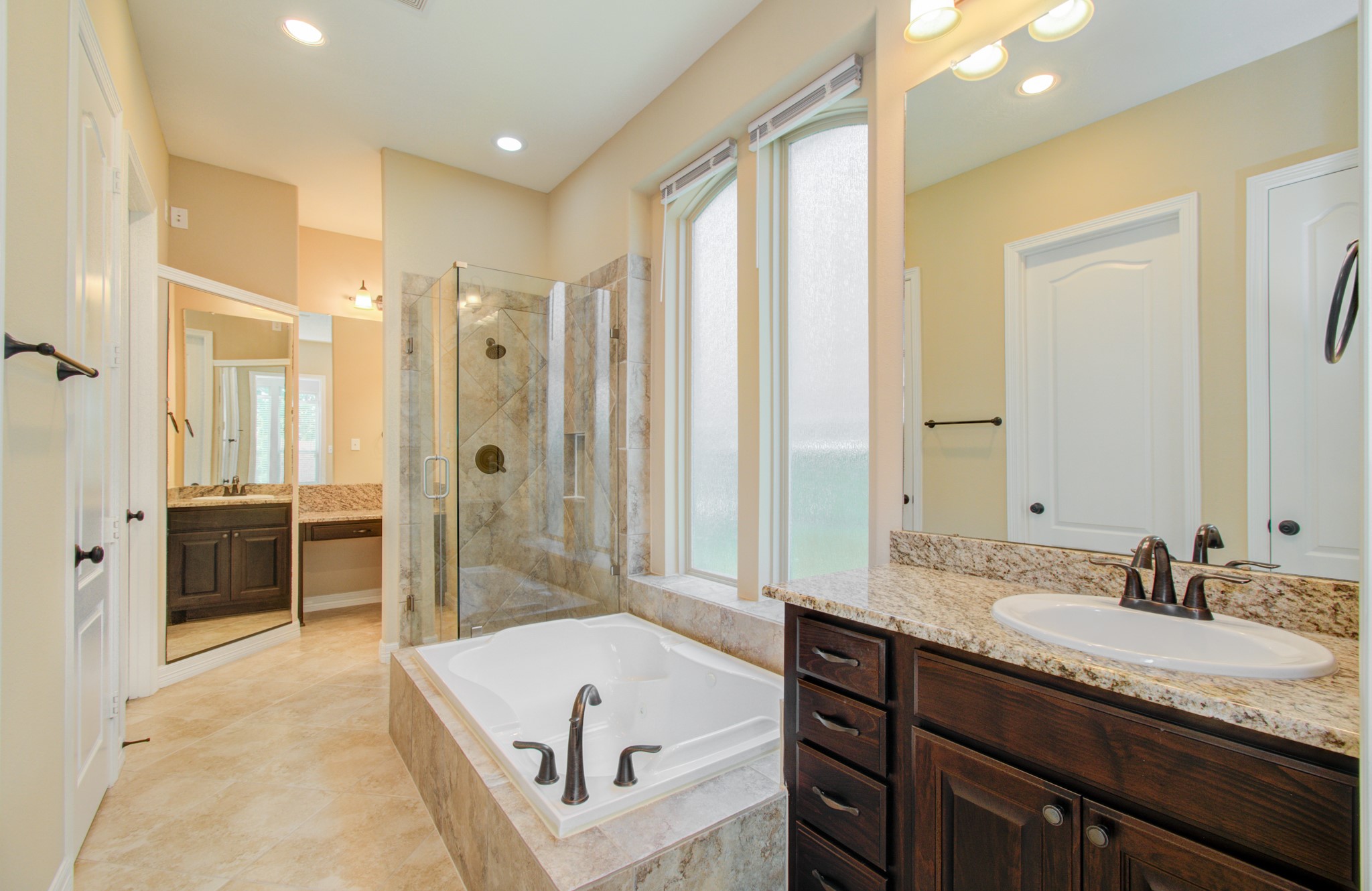 3938 May Ridge Lane Sugar Land, TX 77479 - Photo 21 of 40 a spacious bathroom with a granite countertop sink a tub and a mirror