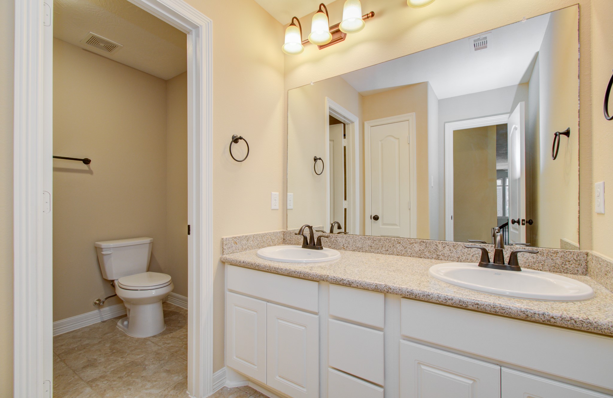 3938 May Ridge Lane Sugar Land, TX 77479 - Photo 33 of 40 a bathroom with a granite countertop sink a toilet and a mirror