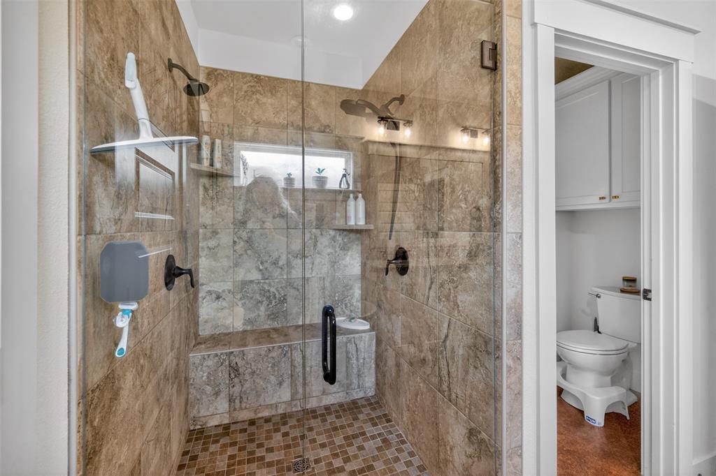 6371 Mill Run Road Athens, TX 75751 - Photo 16 of 40 The bathroom features a spacious shower with glass enclosure, tiled walls and floor, built-in shelving, and a shower bench