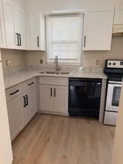 a kitchen with granite countertop a stove sink and cabinets