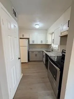 a kitchen with a sink a stove top oven and refrigerator