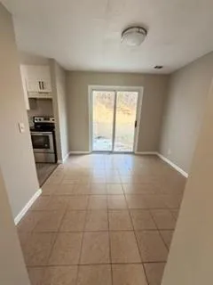 a view of kitchen with granite countertop cabinets and refrigerator