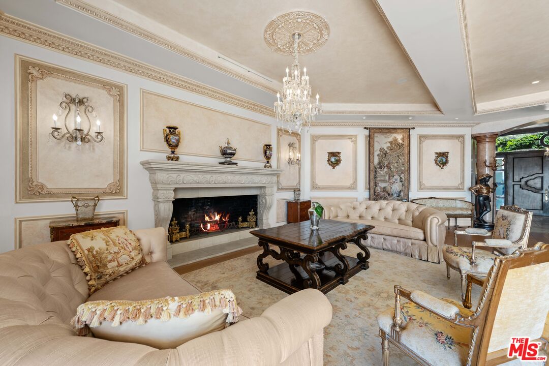 1575 Alexis Place Beverly Hills, CA 90210 - Photo 14 of 75 a living room with furniture a chandelier and a fireplace