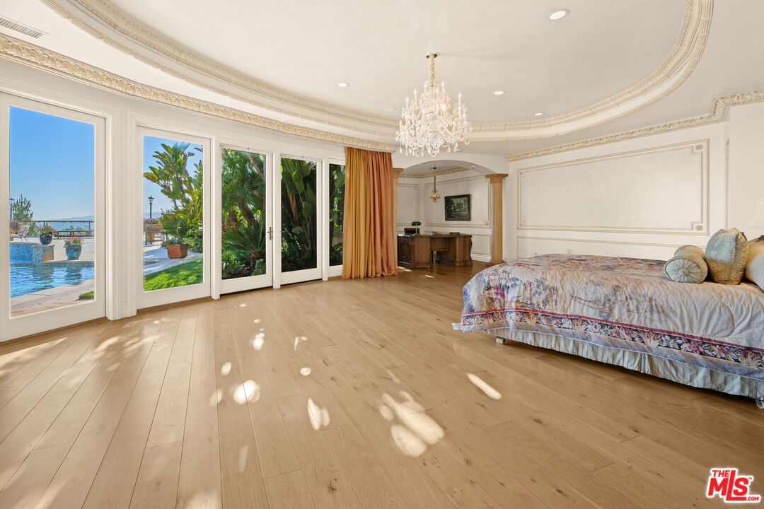 1575 Alexis Place Beverly Hills, CA 90210 - Photo 25 of 75 a spacious bedroom with a bed and a chandelier