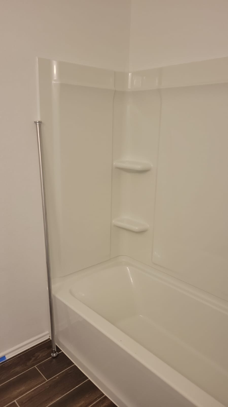 541 Pickrell Loop Georgetown, TX 78628 - Photo 20 of 32 Bathroom featuring a white bathtub with an integrated shower surround, built-in shelving, and dark wood-look floor tiles