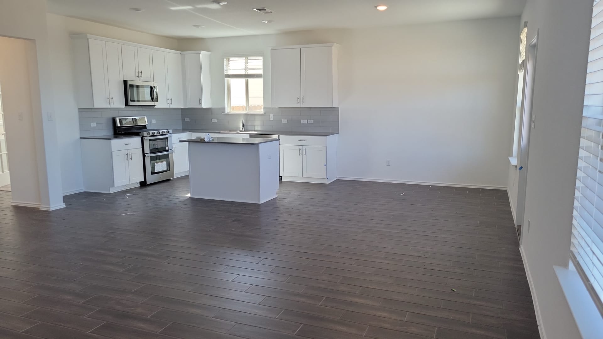 541 Pickrell Loop Georgetown, TX 78628 - Photo 2 of 32 This open-concept living space features dark wood-look flooring, white walls, and recessed lighting