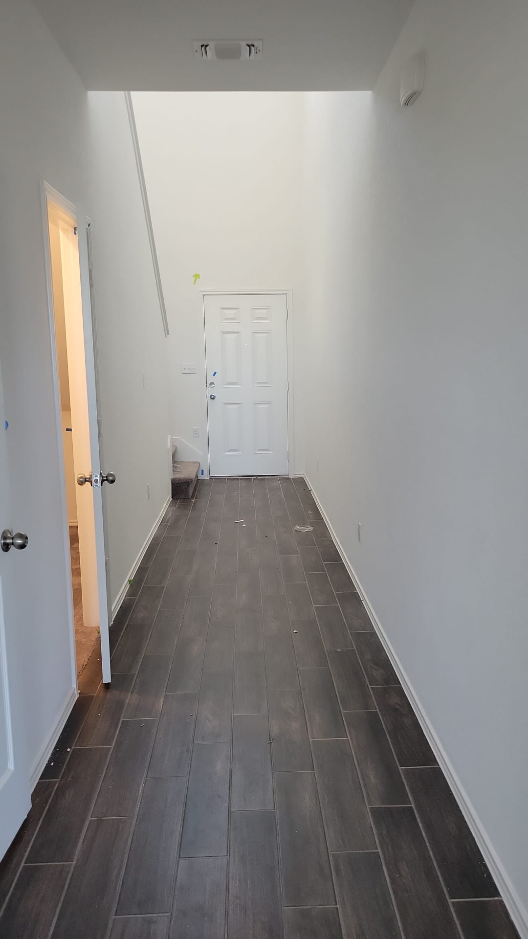 541 Pickrell Loop Georgetown, TX 78628 - Photo 10 of 32 Entryway featuring dark plank-style flooring and white walls, leading to a white paneled door